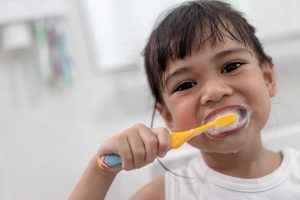 young girl brushing teeth