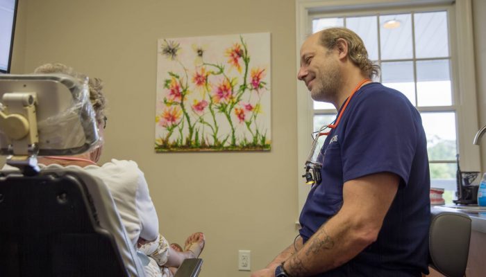 dentist listening patient who sitting in dental chair